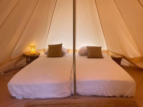 a couple of beds in a tent with a lamp at La calma entre naranjos in Melegis