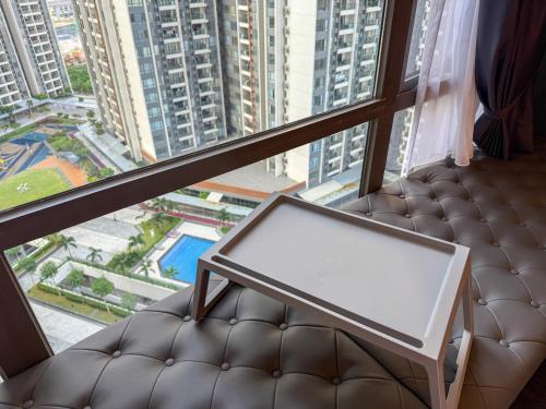 a couch in a room with a large window at R&F Princess Cove by Nest Home at Johor Bahru in Johor Bahru