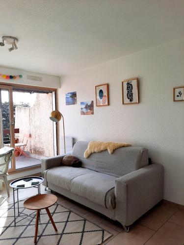 a living room with a couch and a table at Sea view studio in La Ciotat