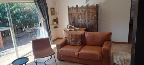 a living room with a couch and a chair at Bloom in Bloemfontein