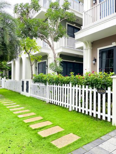 a white picket fence in front of a house at Liséa Wonderland Novaworld Hồ Tràm - Spacious and Cosy Entire Villa by the beach in Xuyên Mộc
