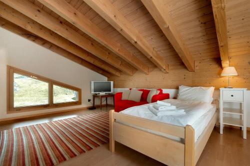 a bedroom with a bed in a room with wooden ceilings at Annika Apartment in Andermatt