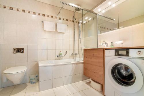 a bathroom with a washing machine and a washer at Annika Apartment in Andermatt