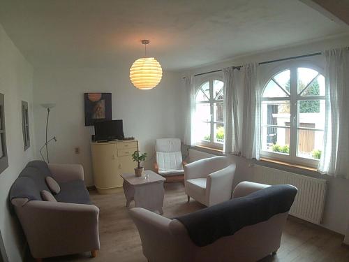 a living room with couches and chairs and windows at Veltenhaus Historic Retreat in Mürlenbach