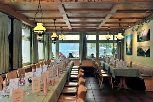 ein Esszimmer mit Tischen, Stühlen und Fenstern in der Unterkunft Hotel Rhodannenberg AG in Glarus