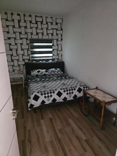 a bedroom with a black and white bed and a wooden floor at Buking in Novi Sad