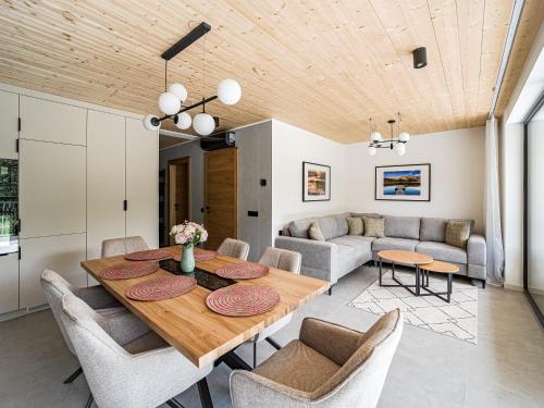 a dining room and living room with a wooden ceiling at Apartamenty Kasztanowa Park Szczyrk in Szczyrk