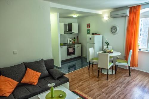 Una sala de estar con un sofá y una mesa y una cocina. en West Wall Apartment, en Split