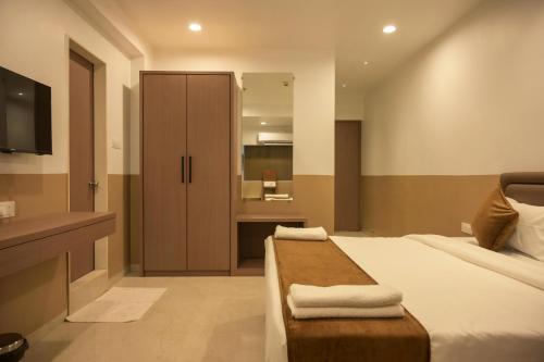 a bedroom with a bed and a bathroom with a sink at Hotel Sagar Presidency A Unit of Buesoco Hospitality Private Limited in Daman