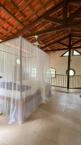 a bed in a room with white mosquito nets at Anjali in Ilha de Boipeba