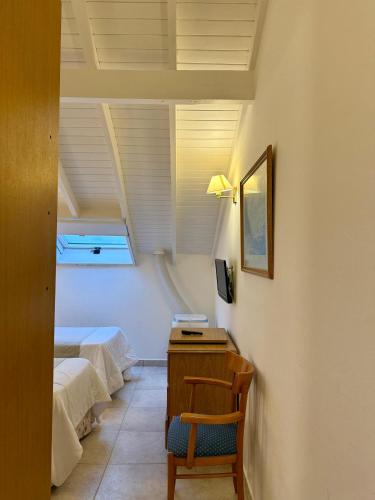 a room with two beds and a desk with a chair at Hotel Soleado in Ostende