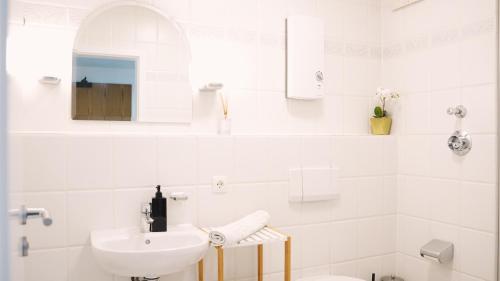 a white bathroom with a sink and a toilet at Apartment mit Balkon, Küche & Waschmaschine an der WHU in Vallendar