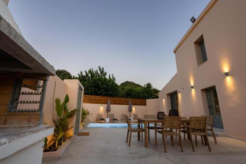 a patio with a wooden dining table and chairs at Roots Villa in Skinés