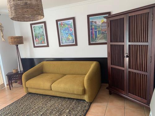 a couch sitting in a living room next to a door at T3 LES PIEDS DANS L'EAU à ST ANNE in Sainte-Anne