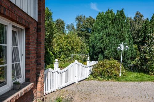 a white fence in front of a house at Gästehaus Ziegler in Neuenkirchen
