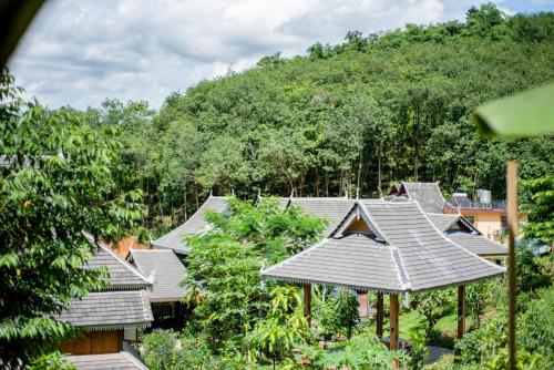 a row of houses with trees in the background at Dai House in Xishuangbanna Village in Menghan