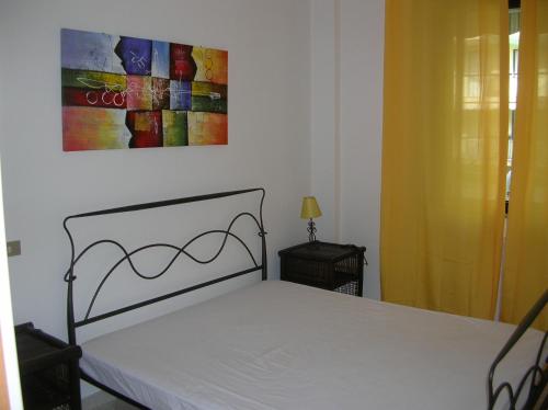アルゲーロにあるCasa Vacanza via Paoliのベッドルーム1室(ベッド1台付)が備わります。壁には絵画が飾られています。