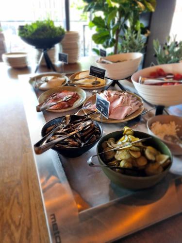 a table with plates and bowls of food on it at Original Sokos Hotel Koljonvirta in Iisalmi