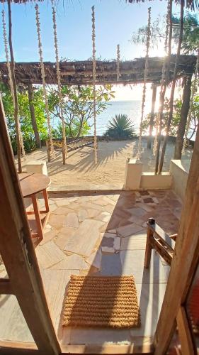 a view of the beach from a porch with a swing at AFYA Village at the sea in Michamvi