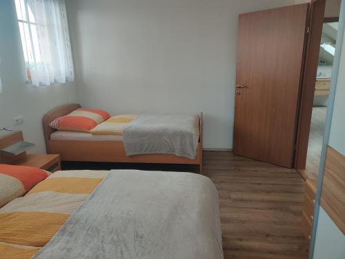 a small room with two beds and a door at Ferienwohnung Oberreiter in Sandl