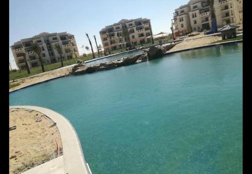 a large body of water with buildings in the background at شاليه بحديقة قريه اركو لاجون العلمين الساحل الشمالي in El Alamein