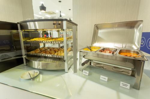 a display case in a bakery with trays of food at Hiber Hotel - Acesso a Chapecó in Chapecó