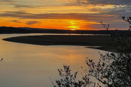 a sunset over a body of water with the sun setting at Harbor Point in Spicewood