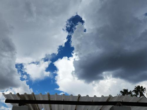 a cloud in the sky with a white fence at Spes Bona guesthouse in Colesberg