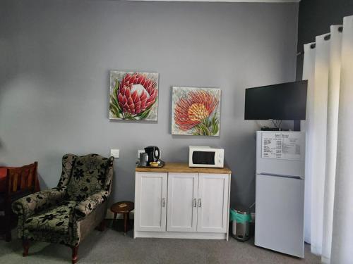 a living room with a chair and a white refrigerator at Spes Bona guesthouse in Colesberg