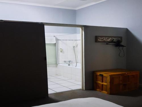 a bathroom with a shower and a bath tub at Spes Bona guesthouse in Colesberg