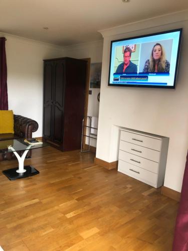 a living room with a flat screen tv on a wall at Gannel View Apartment in Newquay