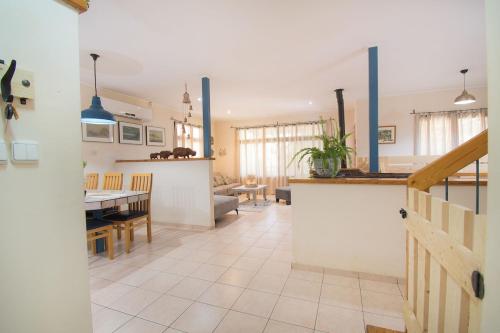 a kitchen and living room with a table and a dining room at Country Cottage Home in Chorazim