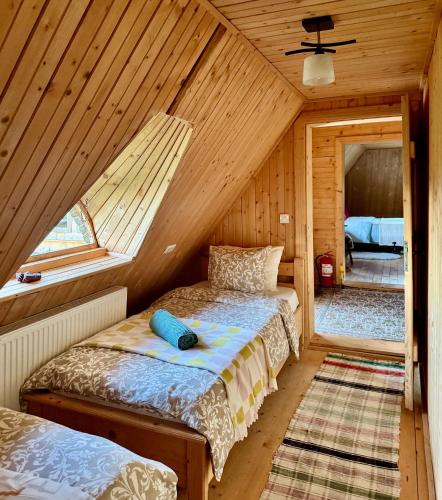 a bedroom with two beds in a wooden cabin at Copacis Country Home in Breb