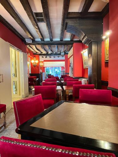 a dining room with red chairs and a table at Hotel Des Deux Continents in Paris