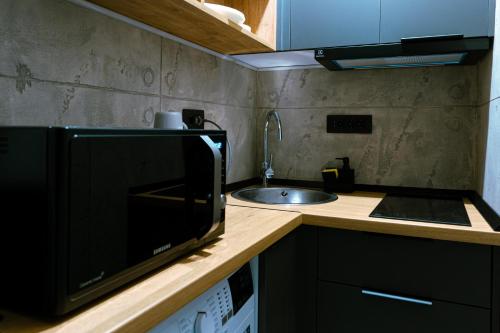 eine kleine Küche mit Mikrowelle und Spüle in der Unterkunft The Industry in Galaţi