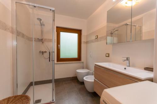a bathroom with a toilet and a sink and a shower at Appartamento Alba sulle Dolomiti in Falcade