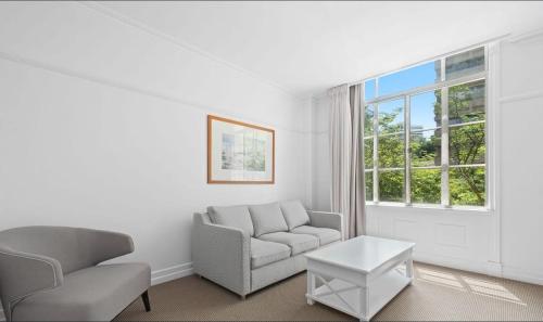 a living room with a couch and a chair and a window at S&P Apartments - Central Station in Brisbane