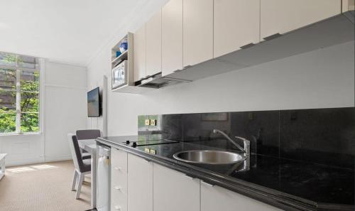 a kitchen with a sink and a counter top at S&P Apartments - Central Station in Brisbane