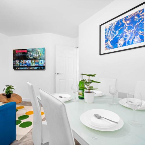 a white dining room with a white table and chairs at Stylish Two Bedroom Apartment - Sleeps Three - Secure Parking - Fast WiFi 53C in Sleightholme