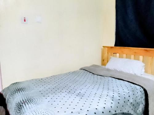 a bedroom with a bed with a black and white comforter at Ghaa Bomet BnB in Bomet
