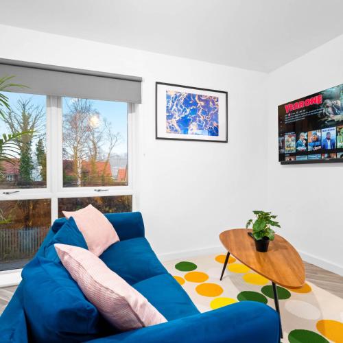 a living room with a blue couch and a table at Stylish Two Bedroom Apartment - Sleeps Three - Secure Parking - Fast WiFi 53C in Sleightholme