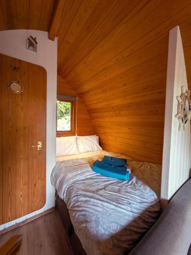 a small bed in a room with a wooden ceiling at The Golden Ball Hotel Pods in Torrisholme