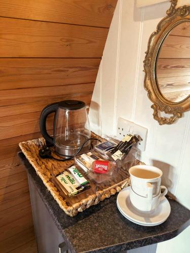 a cup of coffee sitting on a counter with a cup of coffee at The Golden Ball Hotel Pods in Torrisholme