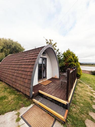 a tiny house with a pitched roof and a deck at The Golden Ball Hotel Pods in Torrisholme