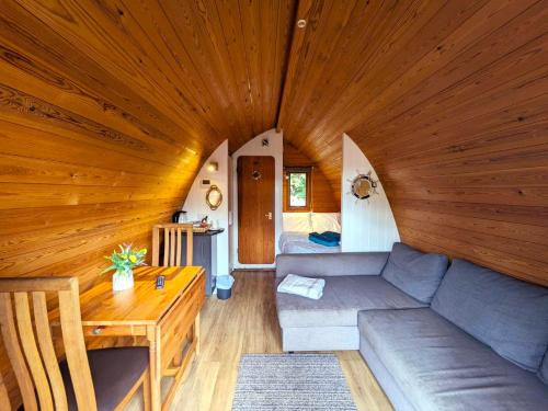 a living room with a couch and a wooden ceiling at The Golden Ball Hotel Pods in Torrisholme