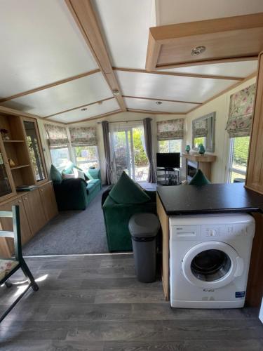 a living room with a washer and dryer in a caravan at The Old Inn Retreat in Spilsby