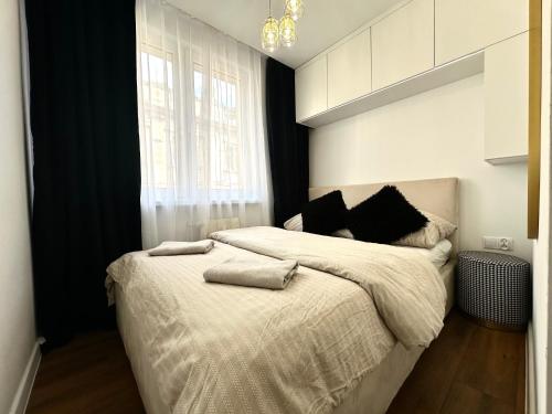 ヴロツワフにあるWita Stwosza 14 Apartment - Check-In 20h - Parkingの白いシーツと窓のあるベッドのある寝室