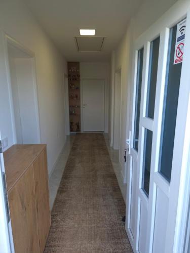 an empty hallway with a door and a room with wine racks at Apartments Halilovic in Hadžići