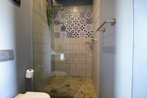 a bathroom with a shower with a toilet at Secure Designer Jozi Apartment With Balcony & Ellis Park Views - Hallmark House in Johannesburg
