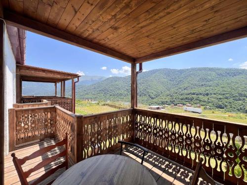a wooden balcony with a view of mountains at Motives Inn Dilijan in Dilijan